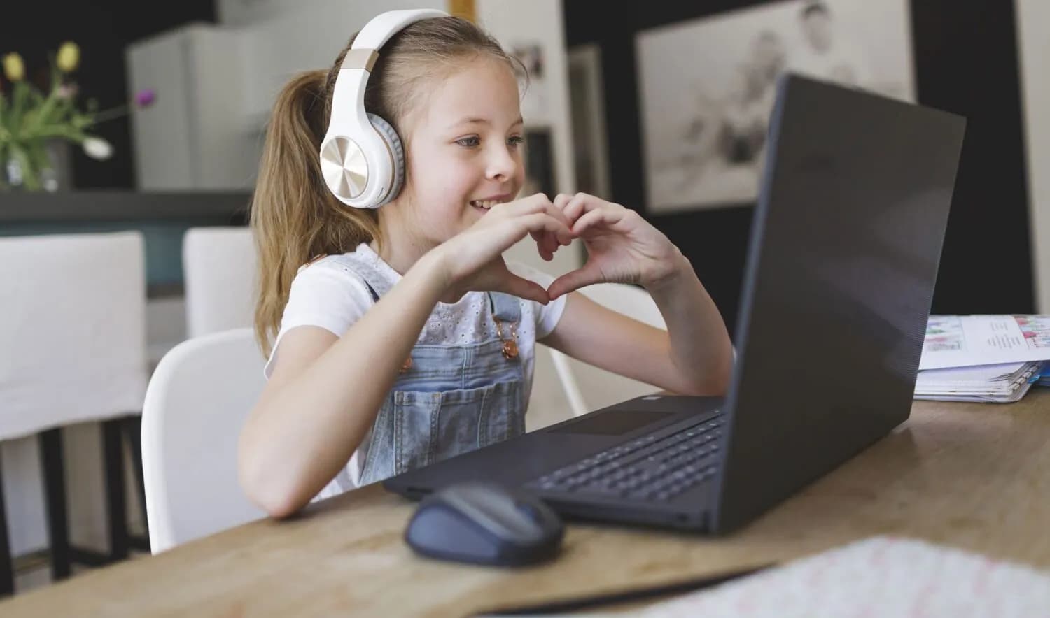 young girl wearing headphones attending online school. about our school